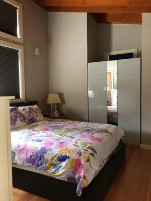 a bedroom with a bed with a floral comforter at Along the Way in Youbou