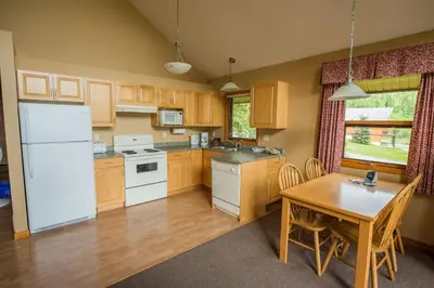 a kitchen with a table and a white refrigerator at Alpine Meadows Resort in Clearwater