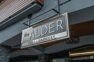 a sign for the aller cafe and grocery on a building at Timberstone Condo by Canadian Rockies Vacation Rentals in Canmore