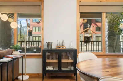 a dining room with windows and a table at Timberstone Condo by Canadian Rockies Vacation Rentals in Canmore