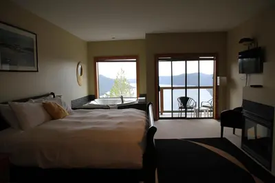 a hotel room with a bed and a balcony at Moon Water Lodge in Malahat