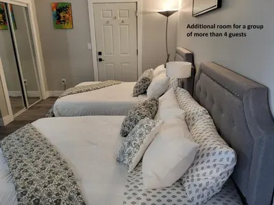 a bedroom with two beds with pillows at Two Bedroom Suite with AC, Sleeps 8- Welcome Snacks and Drinks Included in Langford