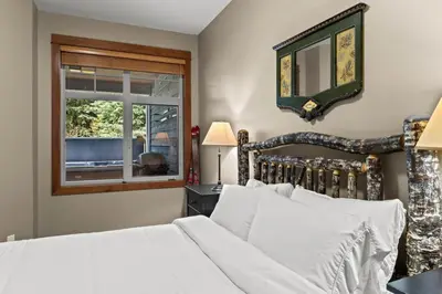 a bedroom with a white bed and a window at Settlers Crossing #35 condo in Sun Peaks