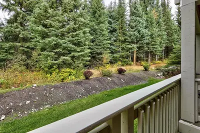 a view from a porch of a yard with trees at Settlers Crossing #35 condo in Sun Peaks