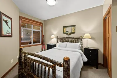 a bedroom with a large bed and a window at Settlers Crossing #35 condo in Sun Peaks