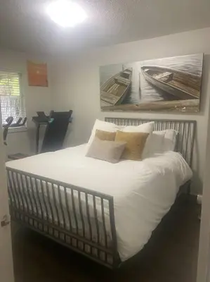 a bedroom with a large bed with white sheets and pillows at Quiet-comfy 4 bedroom house on a quiet tree lined street in Kitsilano in Vancouver