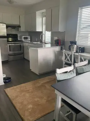 a kitchen with stainless steel appliances and a table and chairs at Quiet-comfy 4 bedroom house on a quiet tree lined street in Kitsilano in Vancouver