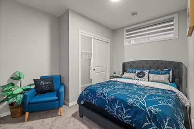 a bedroom with a blue bed and a blue chair at Meriweather - Calgary Breathtaking 1-bedroom apartment in Calgary