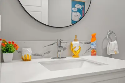 a bathroom with a white sink and a mirror at Meriweather - Calgary Breathtaking 1-bedroom apartment in Calgary