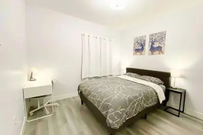 a bedroom with a bed and a desk and a bed sidx sidx sidx at Two Bedroom Suite Burnaby Metrotown in Burnaby