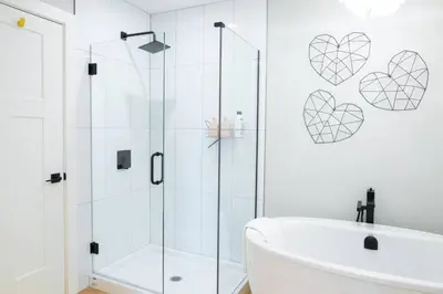 a bathroom with a shower and a tub and a sink at Brand New Penthouse with Lake and Mtn Views in Harrison Hot Springs