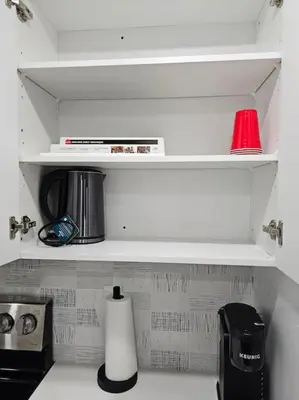 a kitchen with white shelves and a counter top at Cozy 2 bedrooms and 1 bath for 4 guests! in Calgary