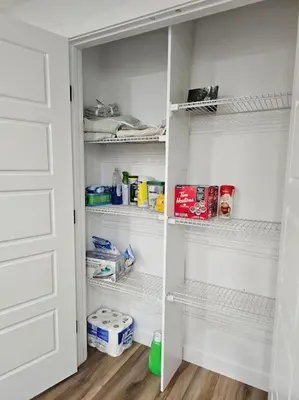 a white closet with white shelves in a room at Cozy 2 bedrooms and 1 bath for 4 guests! in Calgary