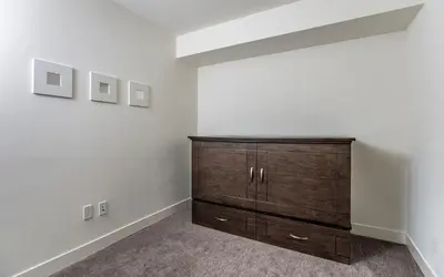 a bedroom with a wooden dresser in a room at L'Austin Rêve by Revelstoke Vacations in Revelstoke