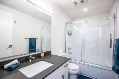a white bathroom with a sink and a shower at L'Austin Rêve by Revelstoke Vacations in Revelstoke