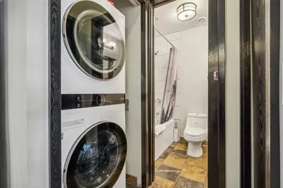 a bathroom with a washing machine and a toilet at Cozy One Bedroom Condo with Indoor Pool and HotTub in Canmore