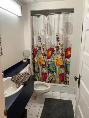 a bathroom with a shower curtain with flowers on it at fabulous beach side apartment in Vancouver