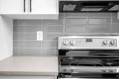 a black and white kitchen with a stove and cabinets at Modern & Spacious Guest Suite in Calgary