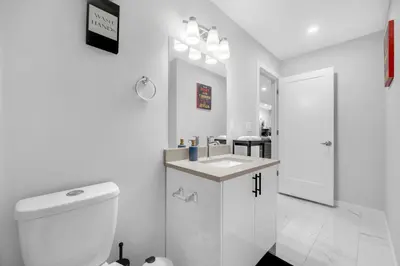 a white bathroom with a toilet and a sink at Modern & Spacious Guest Suite in Calgary