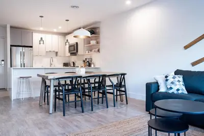 a kitchen and living room with a table and chairs at Drop in Condo by Revelstoke Vacations in Revelstoke