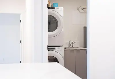 a kitchen with a washer and dryer and a sink at Drop in Condo by Revelstoke Vacations in Revelstoke