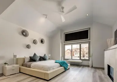a white bedroom with a bed and a window at Newly Renovated Vacation Home w/ Hot Tub & Garage in Calgary