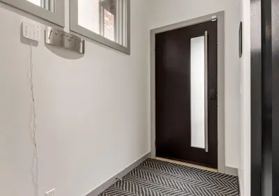 a hallway with a black door and a zebra floor at Newly Renovated Vacation Home w/ Hot Tub & Garage in Calgary