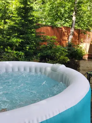 a jacuzzi tub in a backyard at Tiny House with Hot Tub, close to golf and skiing!! in Oyster Bay