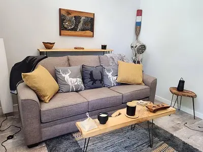 a living room with a couch and a coffee table at Tiny House with Hot Tub, close to golf and skiing!! in Oyster Bay