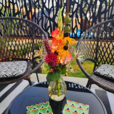 a vase filled with flowers sitting on a table at Tiny House with Hot Tub, close to golf and skiing!! in Oyster Bay