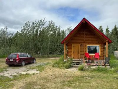 a cabin with a car parked in front of it at Dry Log Cabin with Mountain Views in Upper Laberge