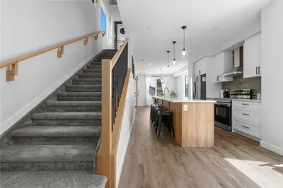 a staircase leading up to a kitchen with white walls at Modern Luxury Home - King Bed•Arcade•WEM•A/C in Edmonton