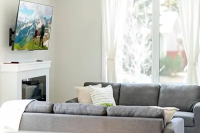 a living room with a gray couch and a fireplace at Modern Luxury Home - King Bed•Arcade•WEM•A/C in Edmonton