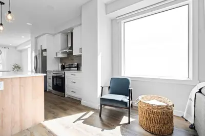 a kitchen with a blue chair and a table at Modern Luxury Home - King Bed•Arcade•WEM•A/C in Edmonton
