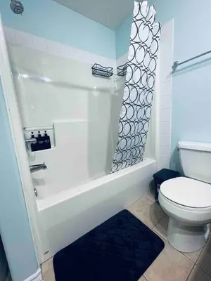 a bathroom with a white tub and a toilet at Modern Upper Level Duplex House in Slave Lake