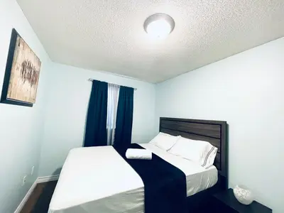 a small bedroom with two beds and a window at Modern Upper Level Duplex House in Slave Lake