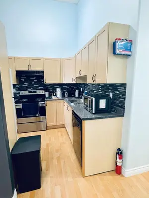 a kitchen with wooden cabinets and a black counter top at Modern Upper Level Duplex House in Slave Lake