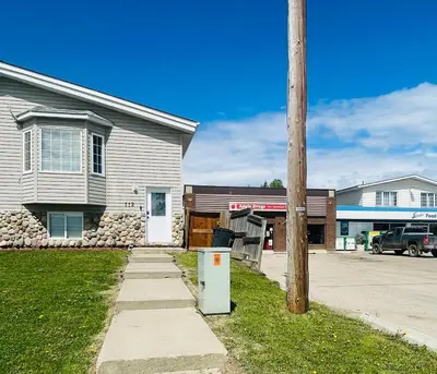a house with a telephone pole next to a street at Modern Upper Level Duplex House in Slave Lake