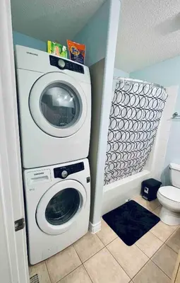 a washing machine in a bathroom next to a toilet at Modern Upper Level Duplex House in Slave Lake