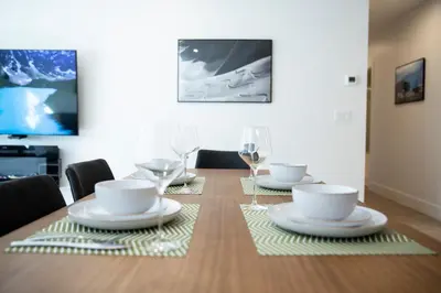 a dining room table with plates and wine glasses at Birdies and Bears by Revelstoke Vacations in Revelstoke