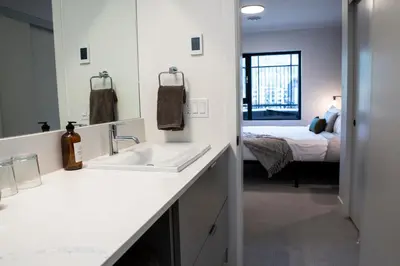 a bathroom with a sink and a bedroom with a bed at Birdies and Bears by Revelstoke Vacations in Revelstoke