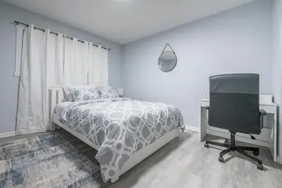 a bedroom with a bed and a desk and a chair at Centre Street 2bed Upper Suite - 4408 in Calgary