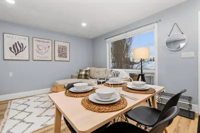 a living room with a wooden table and chairs at Elegant Boho Retreat - 8 min to WEM in Edmonton