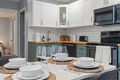 a kitchen with a table with plates and wine glasses at Elegant Boho Retreat - 8 min to WEM in Edmonton