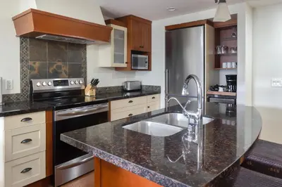a kitchen with a sink and a counter top at Marvellous Mountain Condo- Pets - Pool & Hot Tub managed by Little Sister Getaways in Canmore