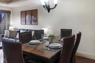 a dining room table with chairs and a couch at Marvellous Mountain Condo- Pets - Pool & Hot Tub managed by Little Sister Getaways in Canmore