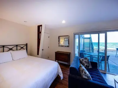 a bedroom with a bed and a view of the ocean at Qualicum Beach Ocean Suites in Qualicum Beach