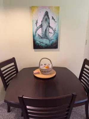 a table with a bowl of fruit and a painting at Gabriola Island B&B By The Sea in Gabriola