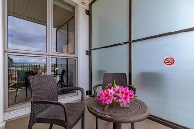 a table with two chairs and a vase of pink flowers at A Gem In This Cityzen Hideaway in Victoria