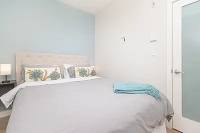 a white bedroom with a large bed with pillows at A Gem In This Cityzen Hideaway in Victoria